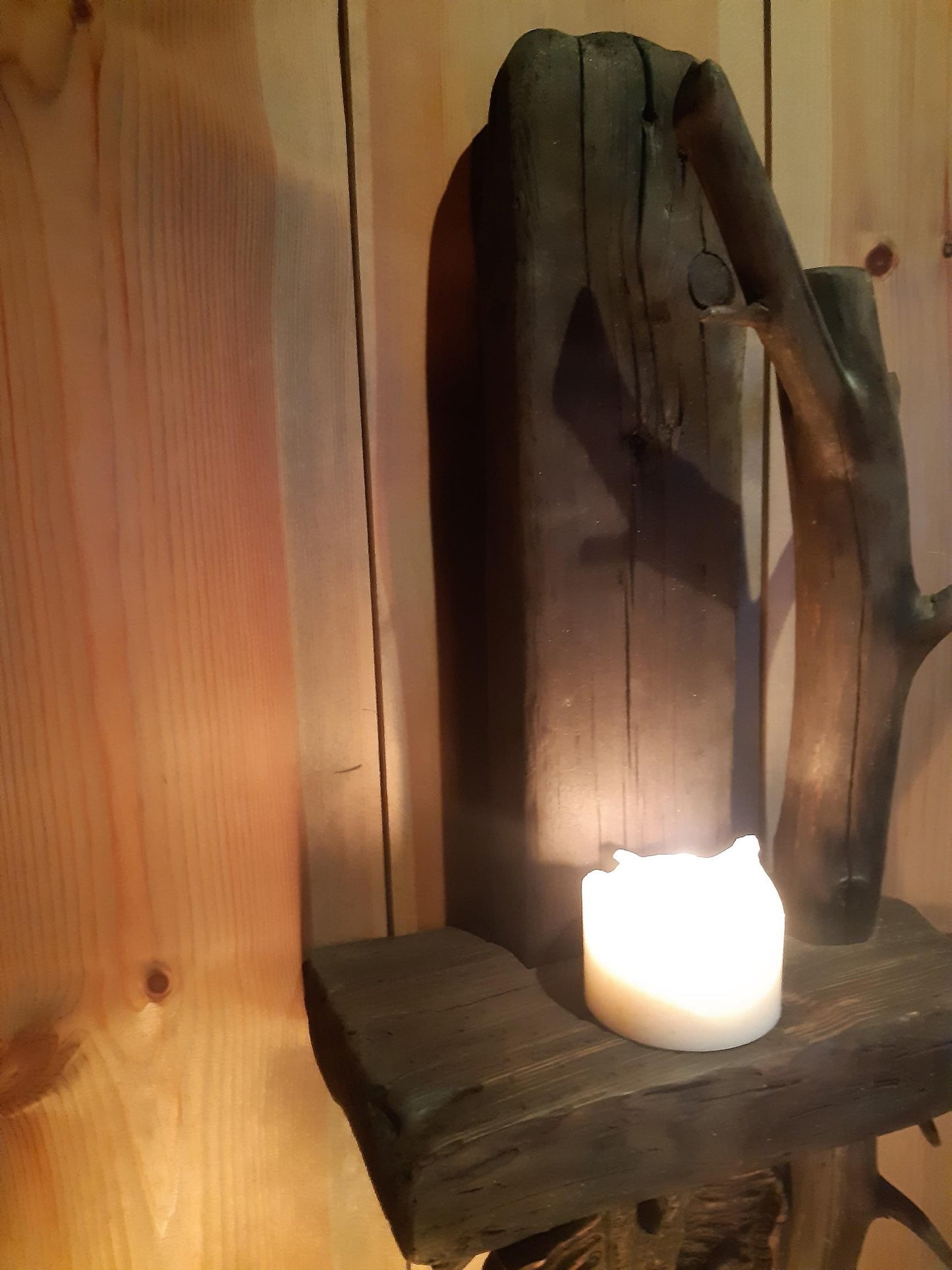 Vegghylle av drivved med hengende håndskåret flaggermus