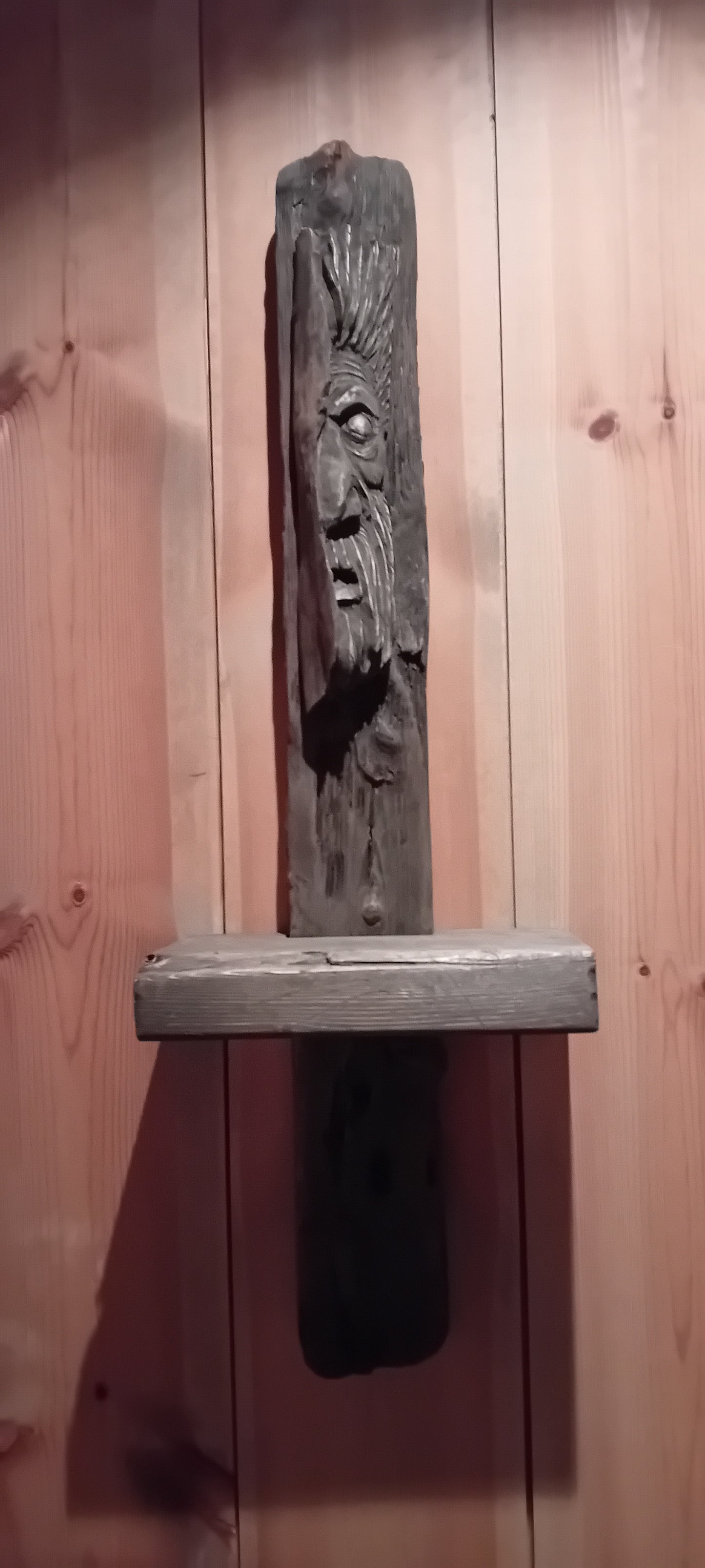 Myrkheimr: Vegghylle av drivved med utskåret treånd.