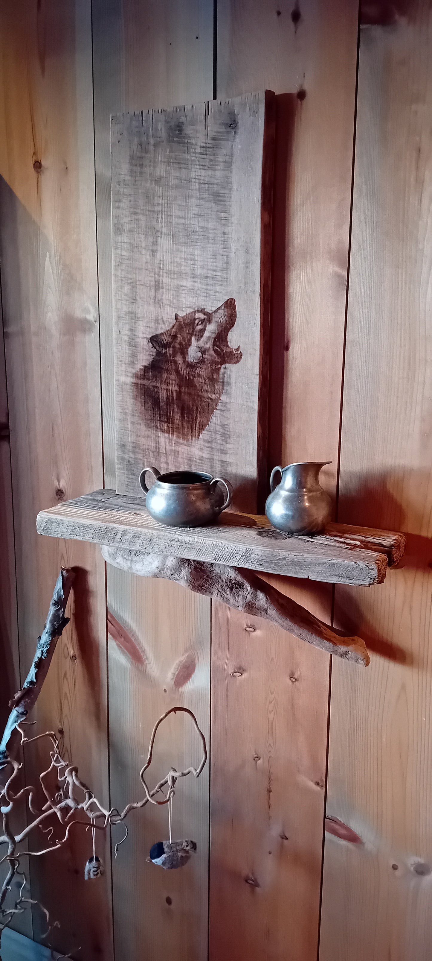 Vegghylle av grånet villmarkspanel og drivved med Ulvemotiv